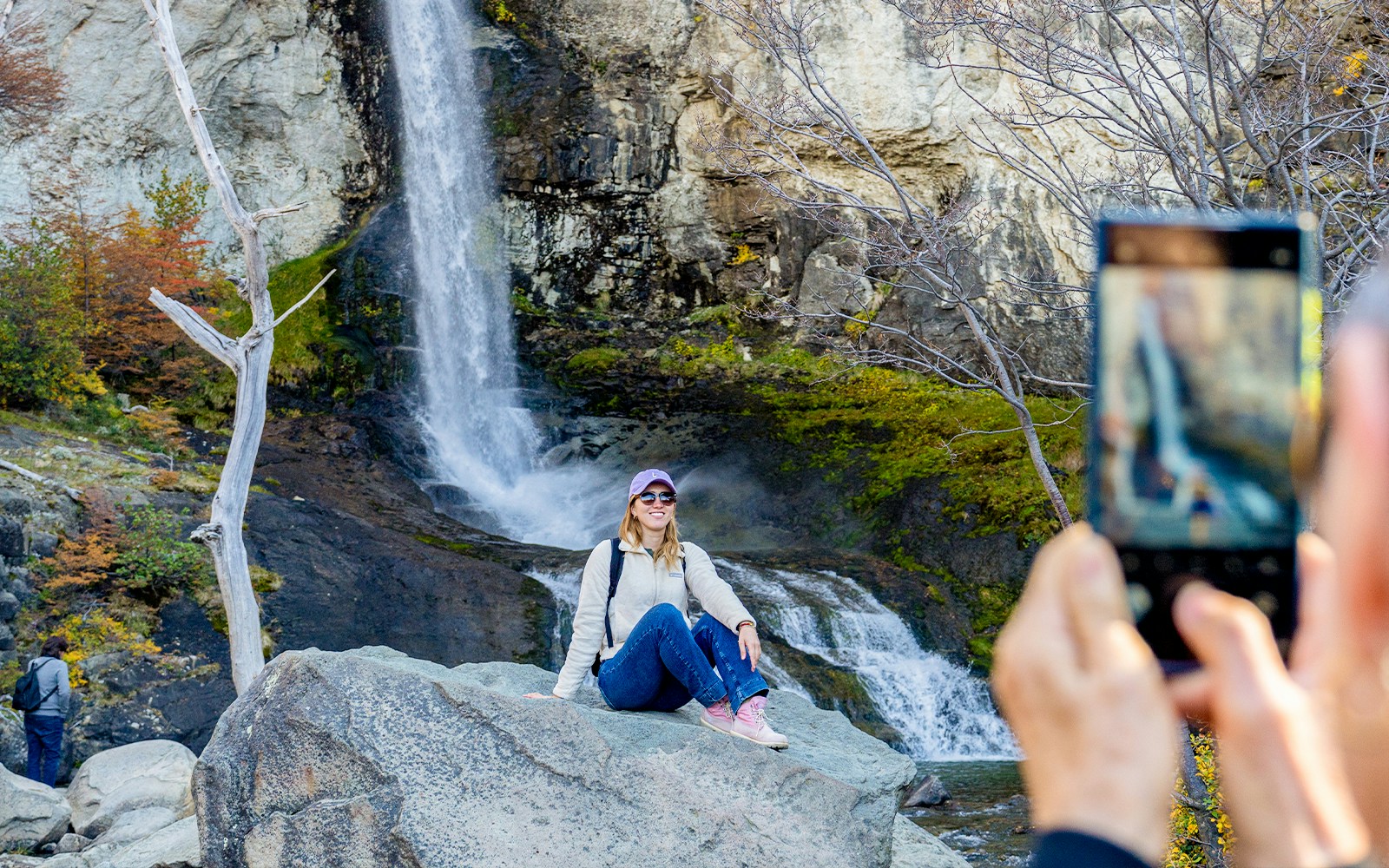 Tourist posing by a small waterfall in El Chaltén, Santa Cruz, Argentina.