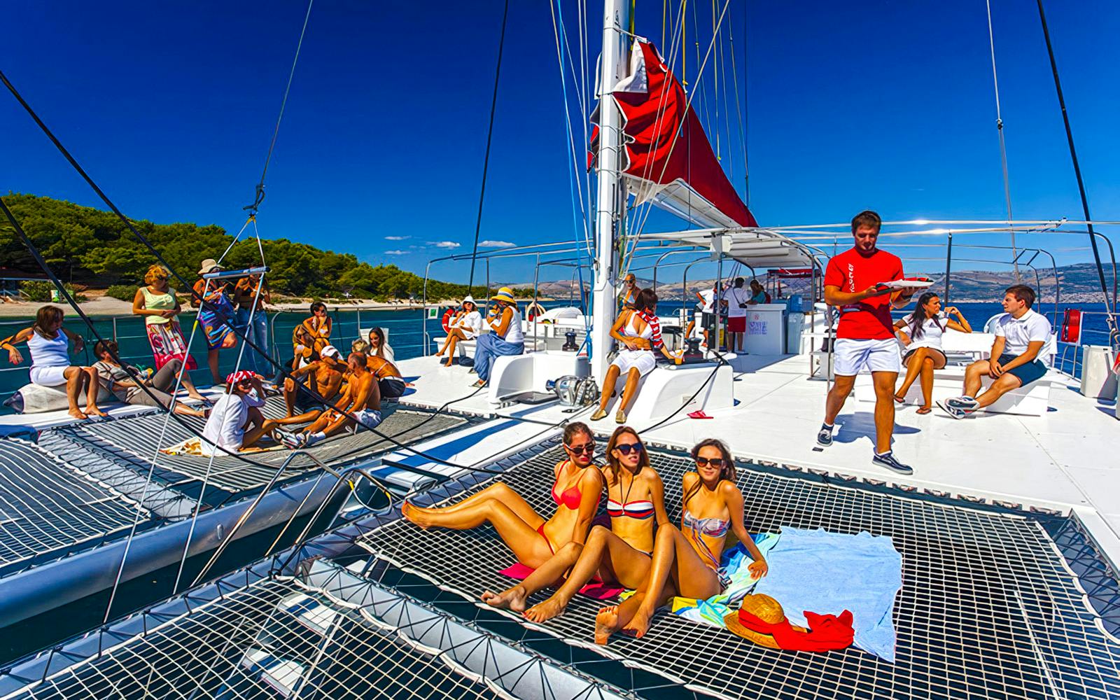 Guests relaxing on a catamaran during the Red Cruise tour in Santorini.