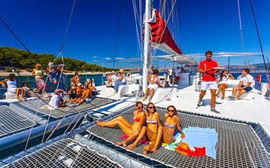 Guests relaxing on a catamaran during the Red Cruise tour in Santorini.