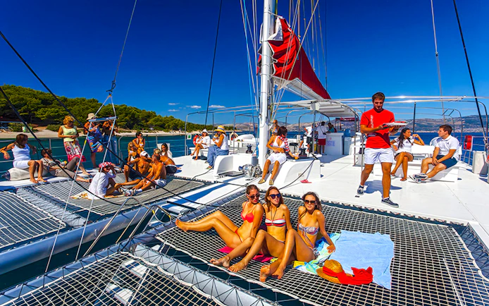 Guests relaxing on a catamaran during the Red Cruise tour in Santorini.