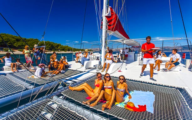 Guests relaxing on a catamaran during the Red Cruise tour in Santorini.