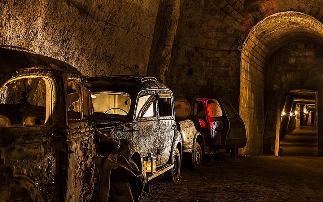 Abandoned vintage cars in the dimly lit Bourbon Tunnel, Naples.
