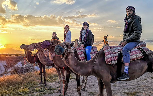 Guided camel ride at sunset in Cappadocia with four riders.