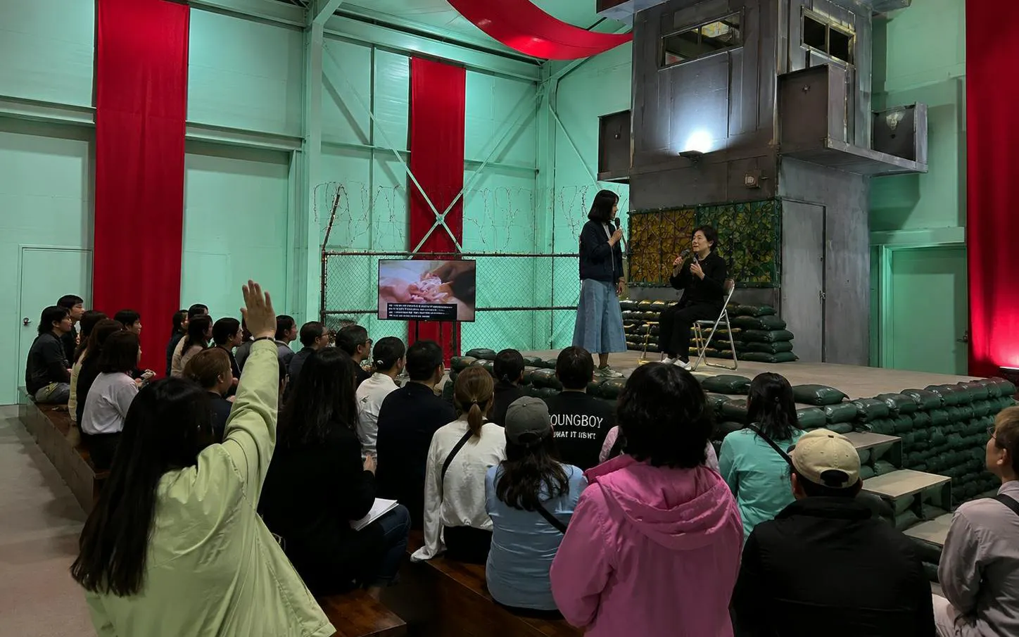 Audience attending a presentation on the DMZ Premium Small Group Tour in North Korea.