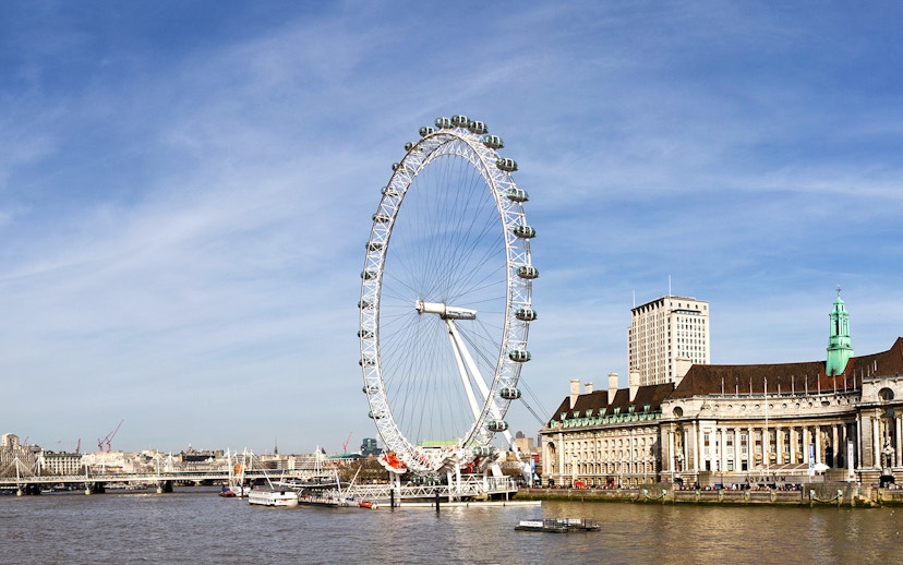 London Eye overlooking the Thames River with cityscape in the background.
