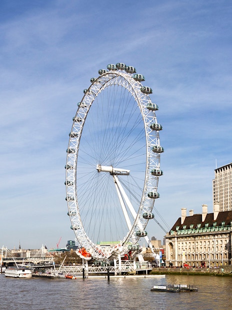 London Eye overlooking the Thames River with cityscape in the background.