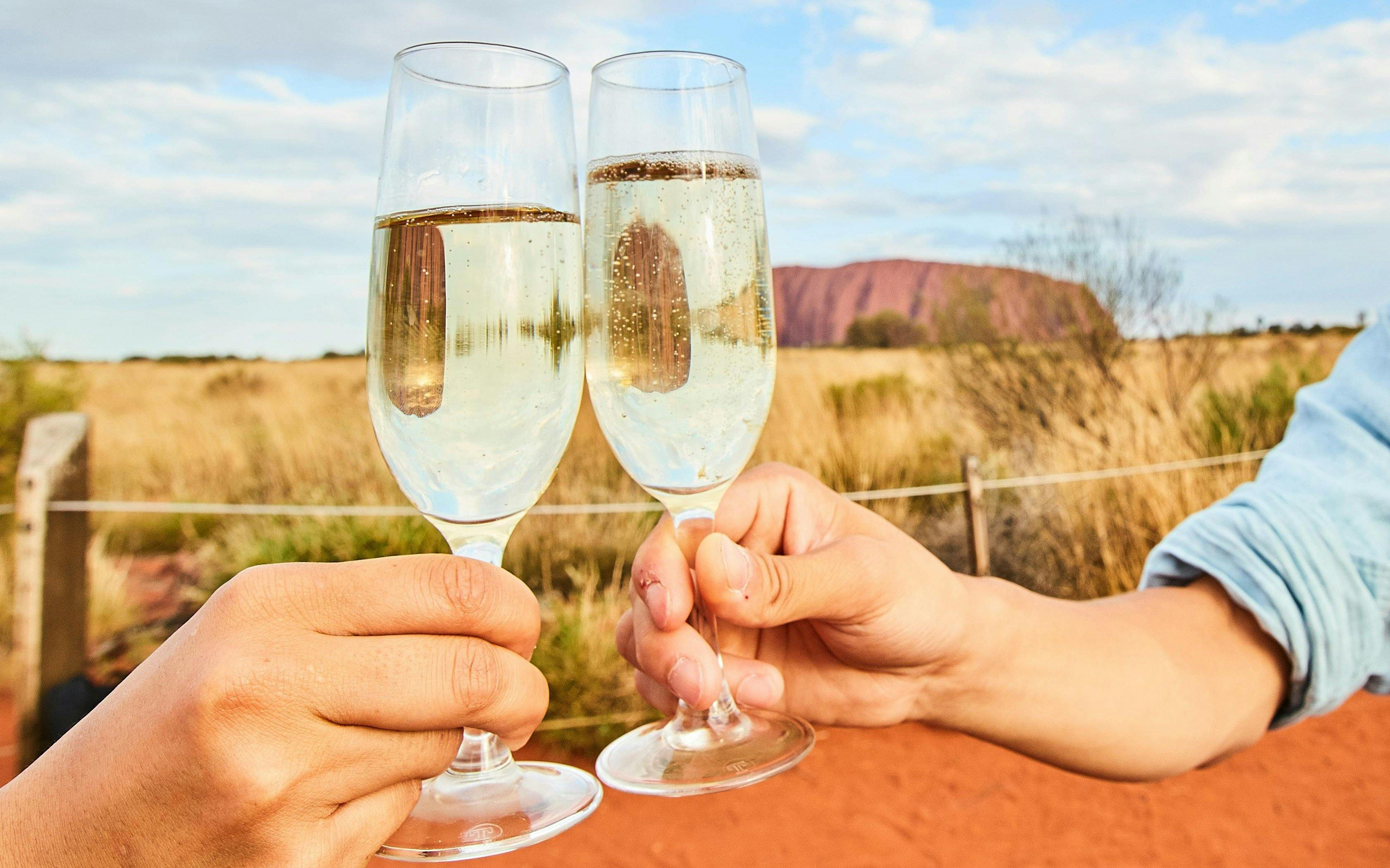 Toasting with sparkling wine at Uluru during sunset tour.