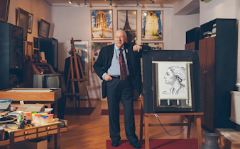 Man standing in art-filled room at House-Museum of Tahir Salahov, Baku, with portrait on easel.