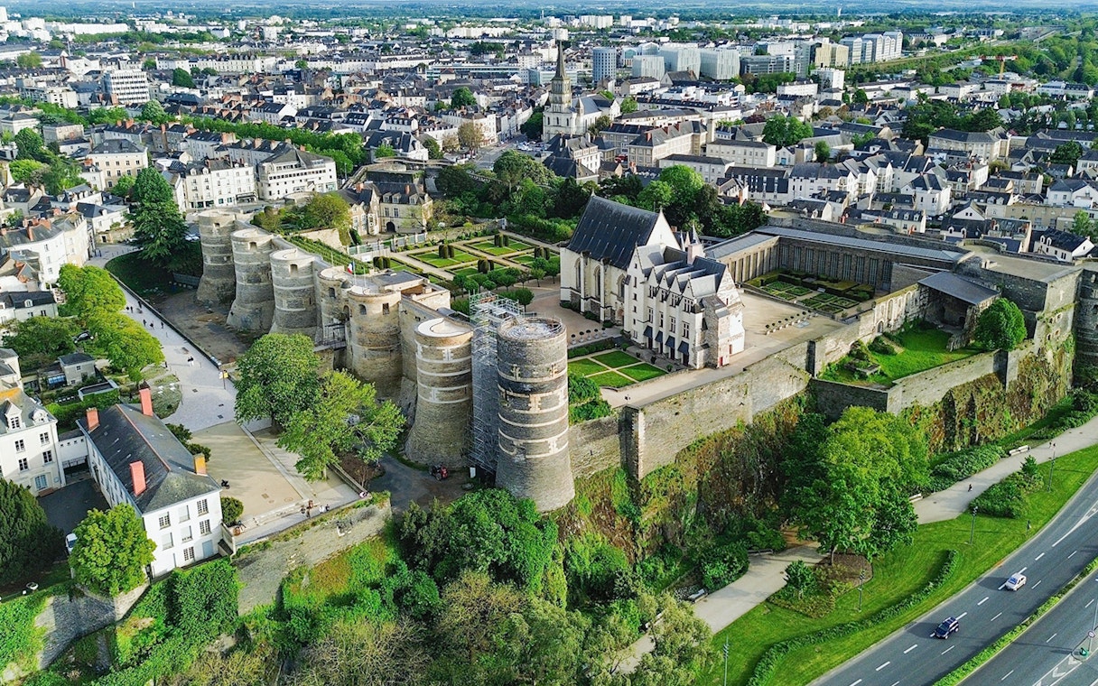 Aerial view of Angers Castle in France with surrounding gardens and cityscape.