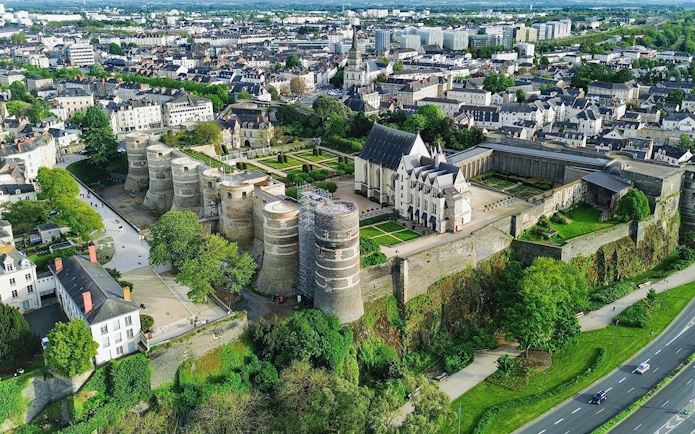 Aerial view of Angers Castle in France with surrounding gardens and cityscape.