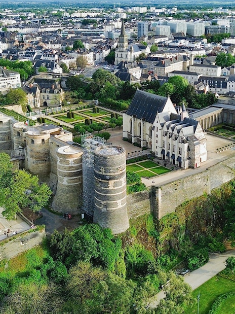 Aerial view of Angers Castle in France with surrounding gardens and cityscape.