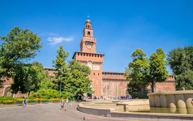 Sforza Castle in Milan with central tower and surrounding gardens.