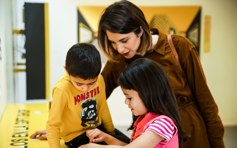 Family exploring interactive exhibit at Museum of Illusions.