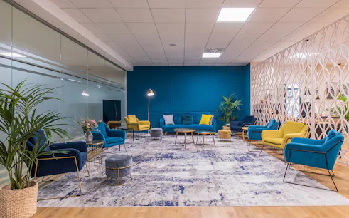 Sleep & Fly Business Center lounge with colorful seating at Barcelona El Prat Airport T1.