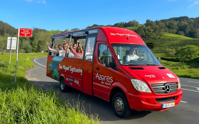 Hop-on hop-off bus with tourists on São Miguel road, Azores.