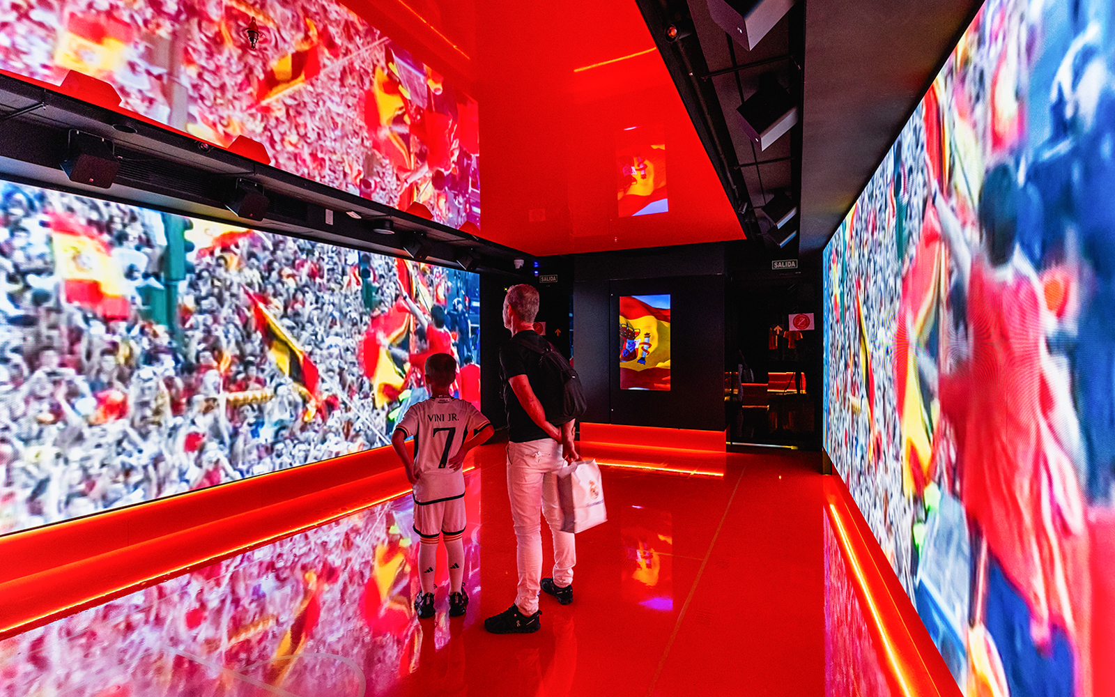 Excited football fans holding Tickets to LEGENDS: The Home of Football tour at a famous stadium
