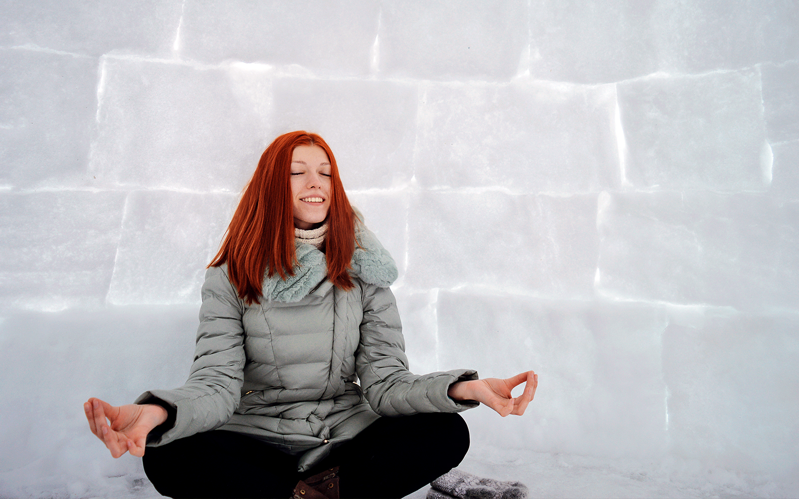 Woman meditating inside an igloo.