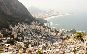 Aerial view of Vidigal favela with Rio de Janeiro coastline in the background.