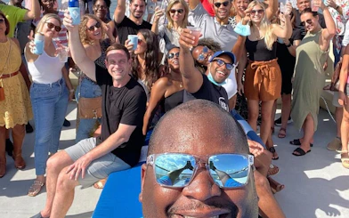 Group enjoying a party on a yacht in Washington, DC with drinks and city views.
