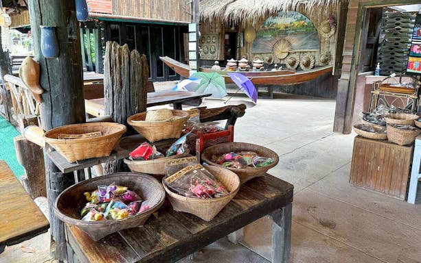 Baskets of local crafts and snacks at a Mae Ping River Cruise stop in Thailand.