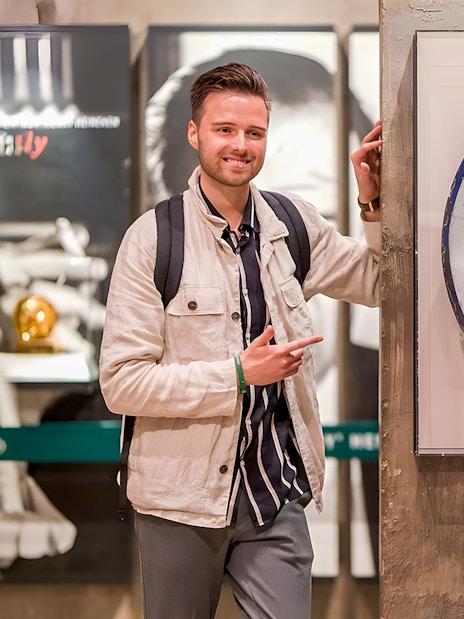 Guests enjoying the Heineken Experience in Amsterdam with a vintage sign.
