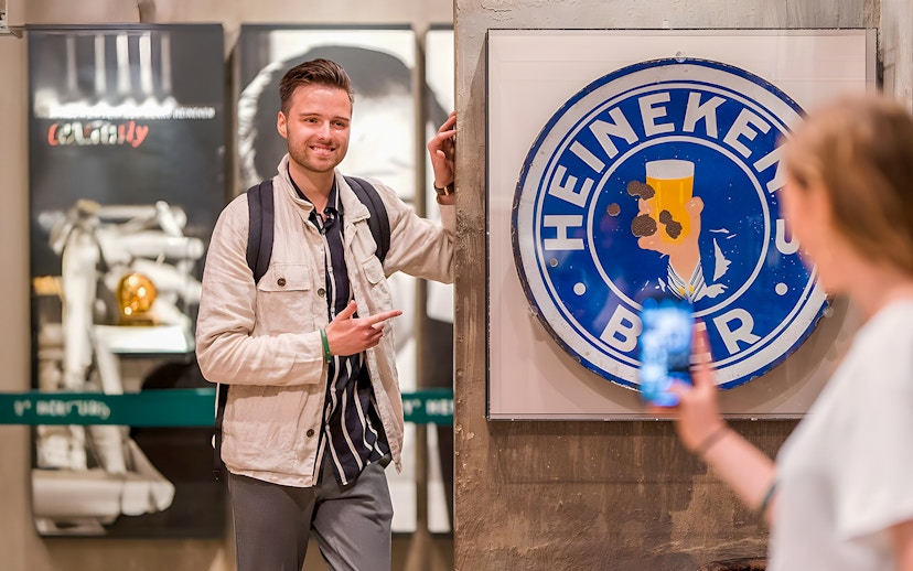 Guests enjoying the Heineken Experience in Amsterdam with a vintage sign.