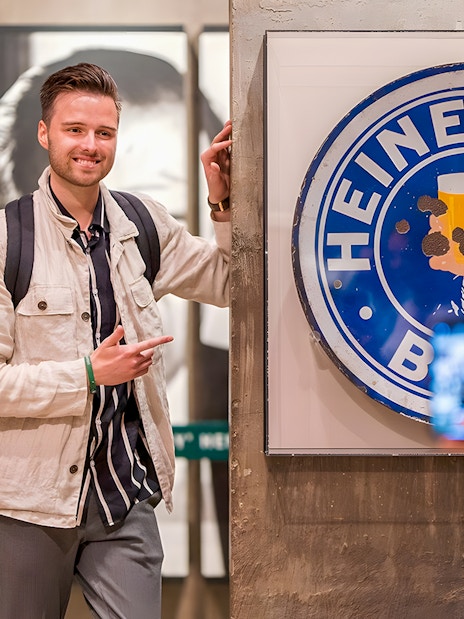 Guests enjoying the Heineken Experience in Amsterdam with a vintage sign.