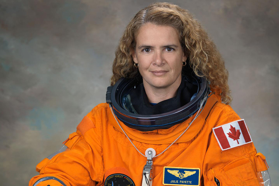 Julie Payette in astronaut suit with Canadian flag patch.