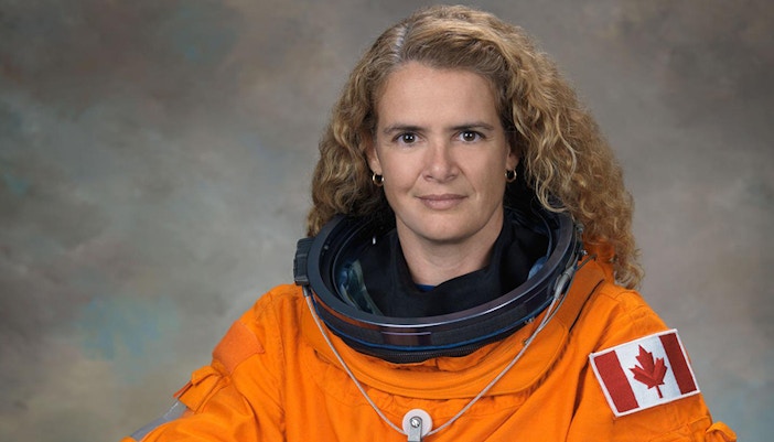 Julie Payette in astronaut suit with Canadian flag patch.