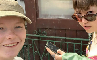 Participants using a smartphone for the Bucharest Spy Game, Operation Troy city exploration.