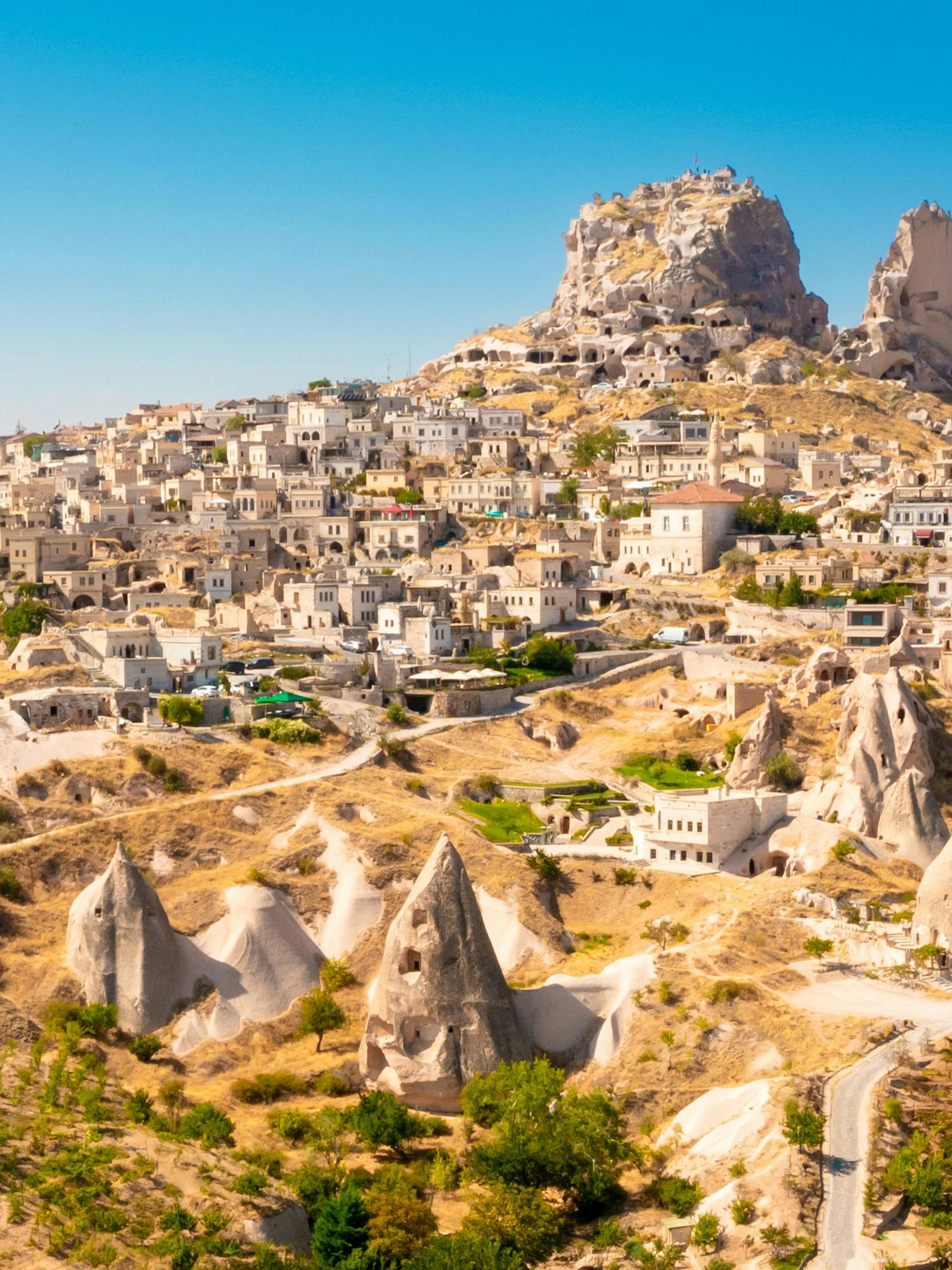 Uchisar Castle atop rock formations in Cappadocia, Turkey, with surrounding village.