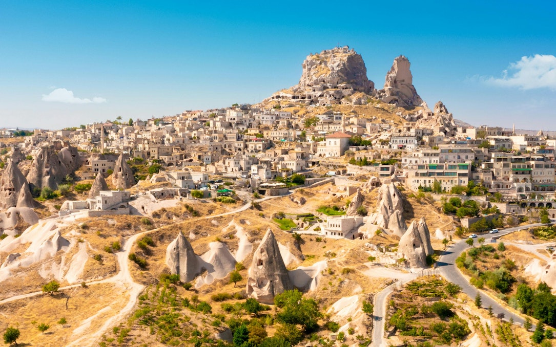 Uchisar Castle atop rock formations in Cappadocia, Turkey, with surrounding village.