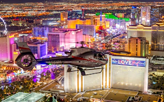 Helicopter flying over illuminated Las Vegas Strip during 60-min Red Rock Canyon tour.
