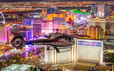 Helicopter flying over illuminated Las Vegas Strip during 60-min Red Rock Canyon tour.