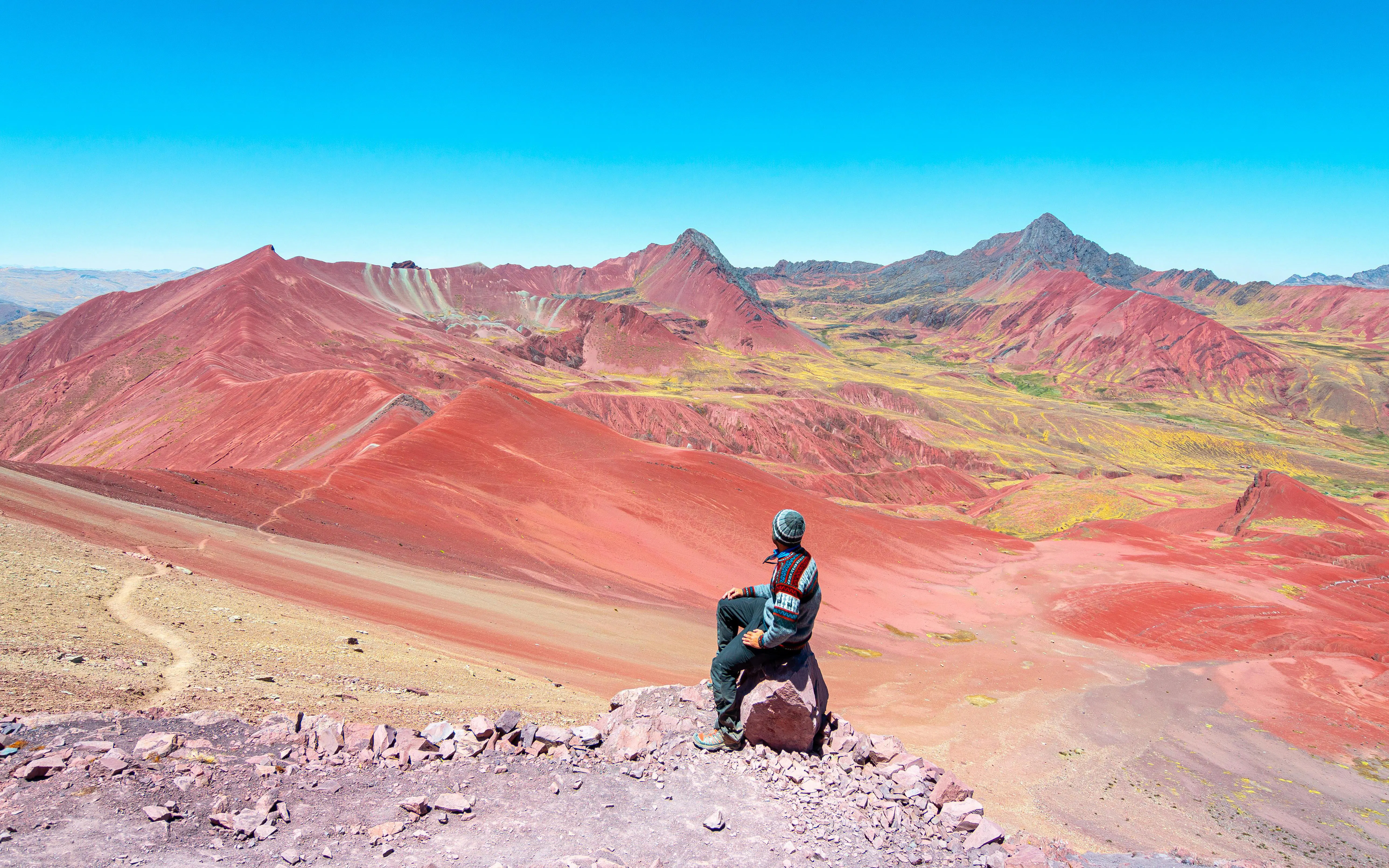 Man photographing Rainbow Mountain landscape in Peru.