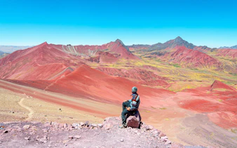 Man photographing Rainbow Mountain landscape in Peru.