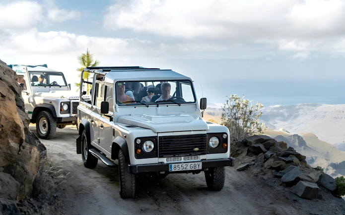 White 4x4 vehicles on a narrow dirt road, Gran Canaria Jeep Safari.