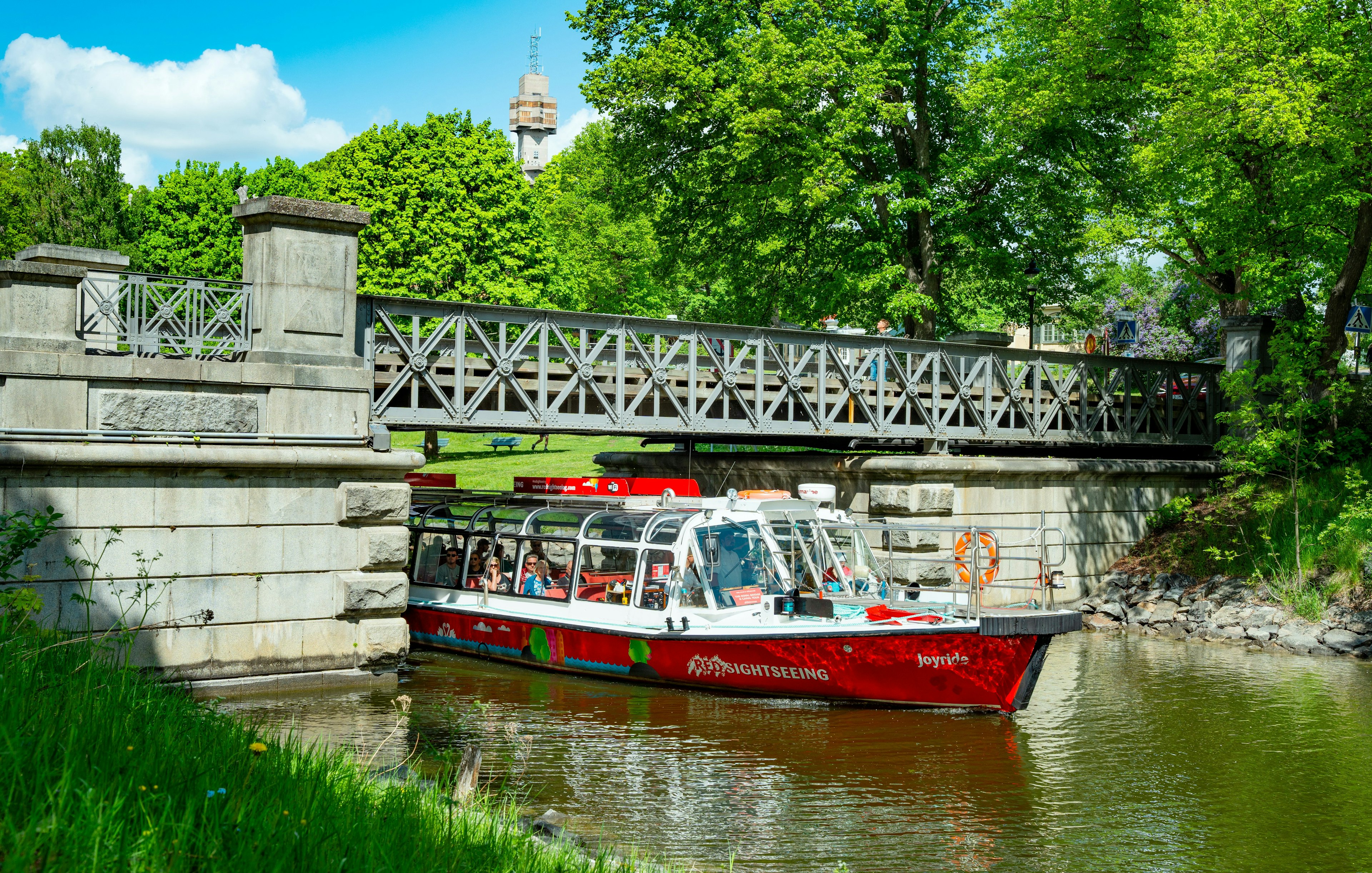 Sightseeing boat on Djurgårdsbrunn Canal, Djurgården, passing under a bridge.
