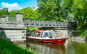 Sightseeing boat on Djurgårdsbrunn Canal, Djurgården, passing under a bridge.