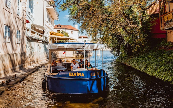 Sightseeing cruise boat on Devils Channel in Prague with passengers.