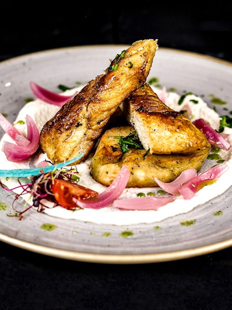 Grilled chicken with pickled onions and herbs on a Budapest Christmas cruise dinner plate.
