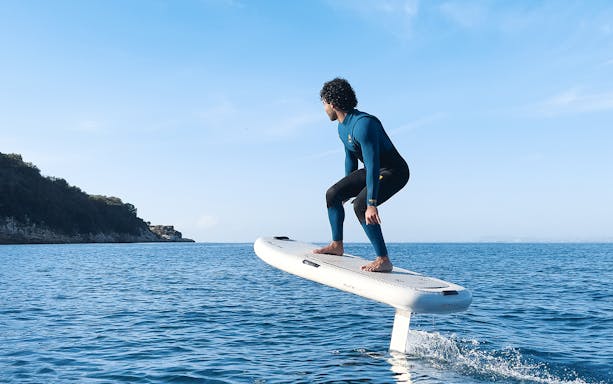 E-foiling on the waters of Capri with a view of the coastline.