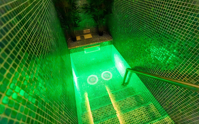 Staircase leading to illuminated pool area at Aquashow Indoor Park.