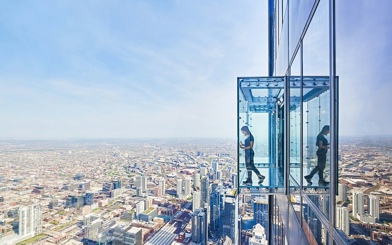 View from Skydeck at Willis Tower, Chicago, overlooking city skyline and Lake Michigan.