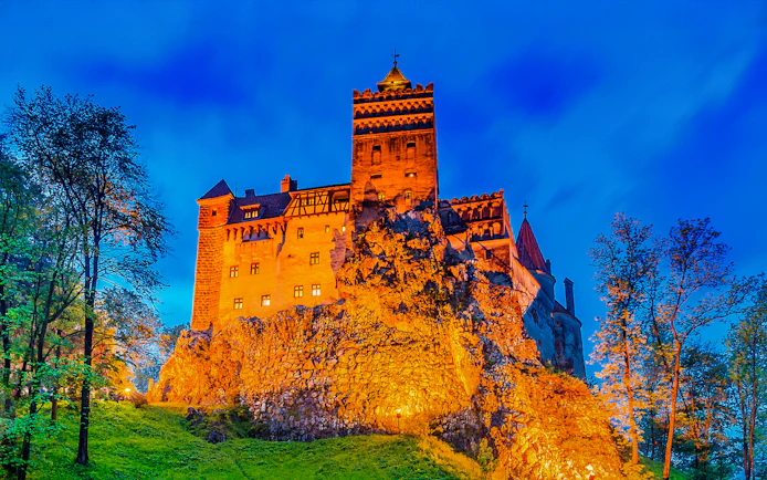 Dracula's Castle illuminated at night in Transylvania, Romania.