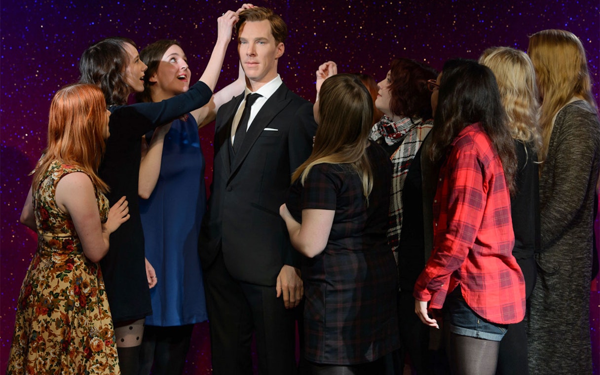 Visitors interacting with a wax figure at Madame Tussauds Hong Kong.
