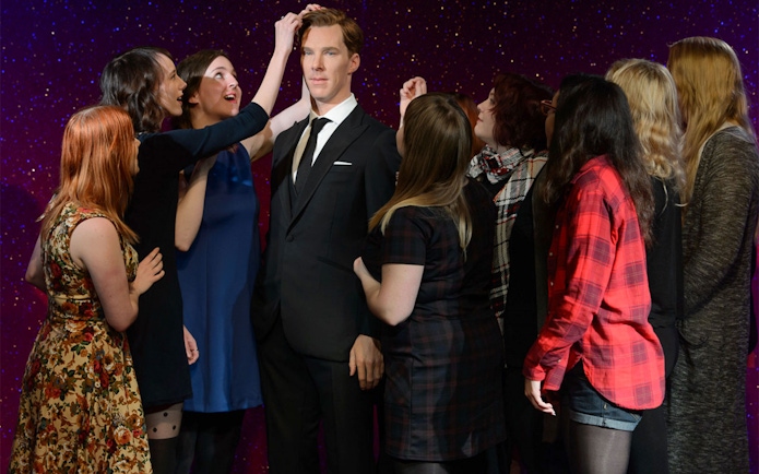 Visitors interacting with a wax figure at Madame Tussauds Hong Kong.