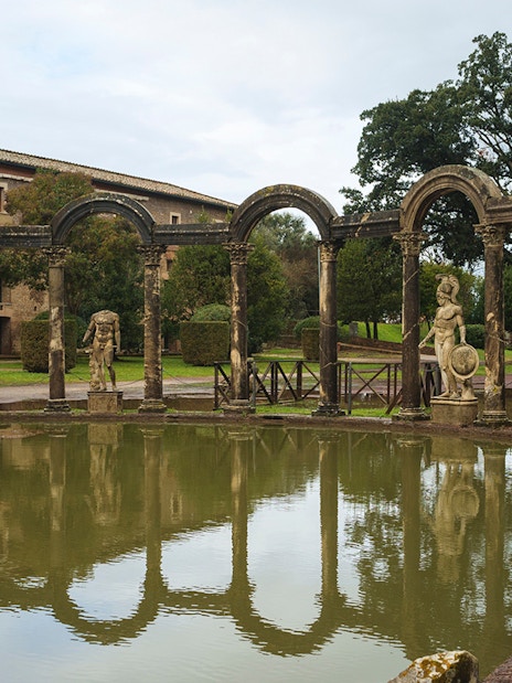 Tivoli's Villa Adriana reflecting pool with ancient statues and arches.