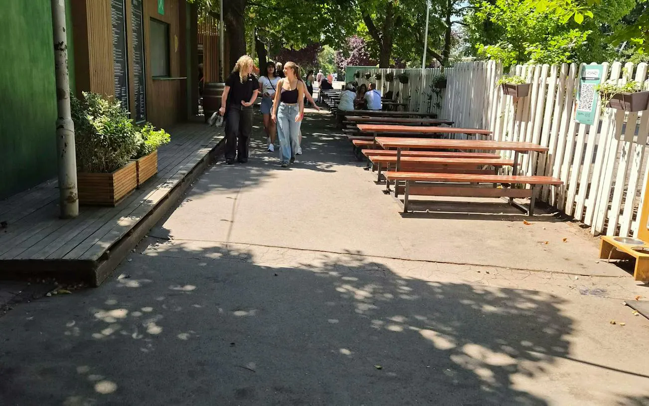 Outdoor seating area in Prague with people walking, part of the Czech it Out Prague Pub Crawl.