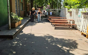 Outdoor seating area in Prague with people walking, part of the Czech it Out Prague Pub Crawl.
